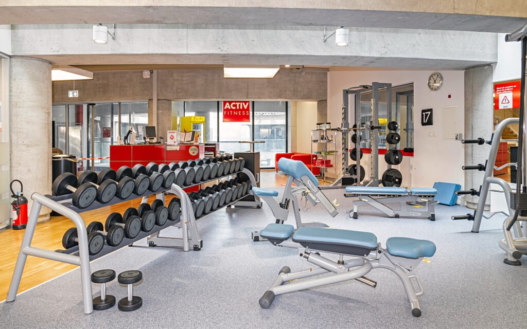 Freihantelbereich mit Kurzhanteln und Squat Rack im ACTIV FITNESS Lausanne Chauderon