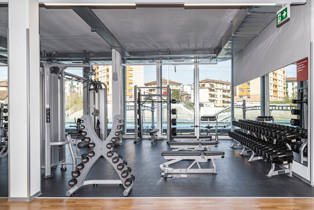 Freihantelbereich mit Kurzhanteln, Langhanteln und Squat Rack im ACTIV FITNESS Renens