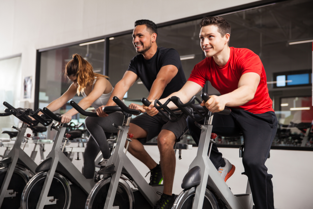 3 Teilnehmende eines Indoor Cycling Kurses im ACTIV FITNESS