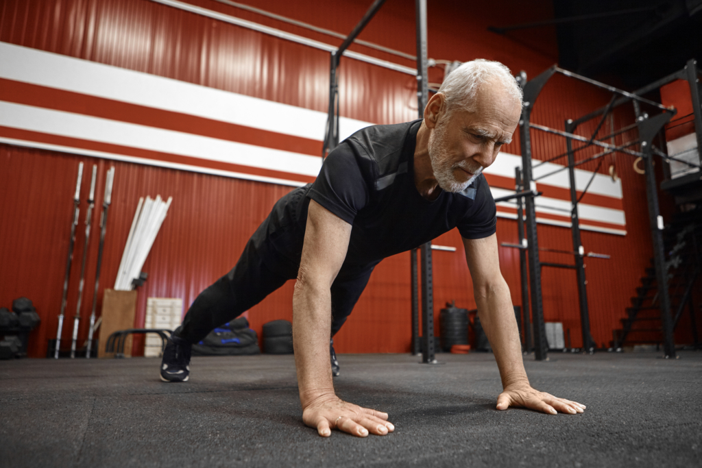Älterer Mann in Liegestützposition beim Vital Fit Kurs im ACTIV FITNESS